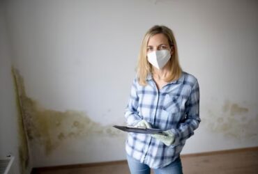 imgi_28_pretty-young-woman-standing-front-wall-with-mold-with-tablet-mouth-nose-mask-person_1048944-24383280